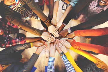 several diverse hands grouped together, aerial view